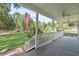 Covered front porch with a white railing offering scenic views of the lush front yard at 7165 Cr 655, Bushnell, FL 33513