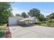 External view of a detached garage with concrete driveway and mature trees at 7165 Cr 655, Bushnell, FL 33513