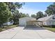 Exterior view of a garage featuring multiple garage doors and a large concrete driveway at 7165 Cr 655, Bushnell, FL 33513