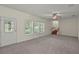 Inviting living room with carpeted floors, bright windows, neutral walls, ceiling fan, and staircase at 7165 Cr 655, Bushnell, FL 33513