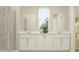 Bright bathroom with white cabinets, double sinks, framed mirrors, and a glass-enclosed shower at 2105 Stake Out Way, Apopka, FL 32703