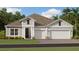 Charming single-Gathering home featuring a two-car garage, neutral siding, and manicured lawn at 2239 Rider Rain Ln, Apopka, FL 32703