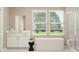 Bright bathroom with a modern tub, glass shower, and vanity with quartz countertops at 2251 Rider Rain Ln, Apopka, FL 32703
