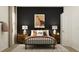 Bedroom with a black accent wall, a metal frame bed, and stylish nightstands at 2251 Rider Rain Ln, Apopka, FL 32703
