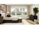 Bright main bedroom featuring a bed with decorative pillows, a dresser, and large windows at 2251 Rider Rain Ln, Apopka, FL 32703