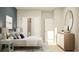 Bright bedroom featuring a white bed, blue accent pillows, and a stylish gray nightstand at 2341 White Buffalo St, Apopka, FL 32703