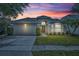 Charming single Gathering home with a well-maintained lawn, two car garage and beautiful landscaping at sunset at 2719 Osprey Creek Ln, Orlando, FL 32825