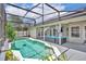 Covered swimming pool with blue patio furniture set and green plants around the pool at 2719 Osprey Creek Ln, Orlando, FL 32825
