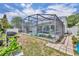 Exterior yard view with a grill, green plants, and a brick walking path to the pool at 2719 Osprey Creek Ln, Orlando, FL 32825