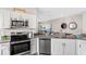 Modern kitchen features stainless steel appliances, gray countertops and cabinetry with an open concept design to the living room at 3282 Armstrong Ave, Clermont, FL 34714