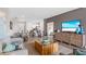 Open-concept living room featuring hardwood floors, a comfortable sofa, and a large TV for entertaining at 3282 Armstrong Ave, Clermont, FL 34714