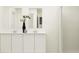Bathroom features double sinks, modern cabinets, decorative vases, and a tiled shower with a curtain at 463 Puma Loop, Groveland, FL 34736