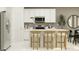 Bright, eat-in kitchen features white cabinets, stainless steel appliances, and a quartz-topped breakfast bar at 463 Puma Loop, Groveland, FL 34736