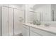 Bright bathroom featuring dual sinks, a modern vanity, and a glass-enclosed shower at 5611 Vinyasa Rd, Clermont, FL 34714