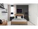 Modern bedroom with stylish decor, featuring a black accent wall and neutral furnishings at 5660 Vinyasa Rd, Clermont, FL 34714