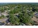 An aerial view shows the property surrounded by lush trees and a glimpse of a nearby lake at 1205 Crestwood Dr, Winter Haven, FL 33881