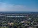 Overhead aerial view of the neighborhood with lush tree coverage and a lake in the distance at 1205 Crestwood Dr, Winter Haven, FL 33881