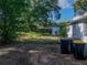 Side view of the home and spacious backyard with mature trees, ample privacy, and room for activities at 1205 Crestwood Dr, Winter Haven, FL 33881