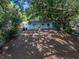 Backyard with mature tree, featuring home exterior with trash receptacles at 1205 Crestwood Dr, Winter Haven, FL 33881