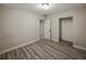 This bedroom features modern gray wood floors, white walls, and a closet at 1205 Crestwood Dr, Winter Haven, FL 33881