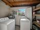 This is a functional laundry room with washer, dryer, and extra storage shelving at 1205 Crestwood Dr, Winter Haven, FL 33881