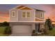 Two-story home featuring a two-car garage, gray siding, and a cozy front porch at 1752 Frogmore Ave, Haines City, FL 33844