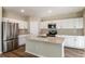 Modern kitchen features white cabinets, stainless steel appliances, and a large center island at 1752 Frogmore Ave, Haines City, FL 33844