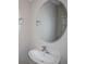 A bathroom with a white sink, faucet, and oval mirror at 1756 Frogmore Ave, Haines City, FL 33844