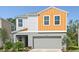 Two-story home featuring a two-car garage, and landscaping in front of the home at 1756 Frogmore Ave, Haines City, FL 33844