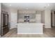 A large kitchen with stainless steel appliances, a quartz island and light gray cabinets at 1756 Frogmore Ave, Haines City, FL 33844