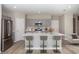 Modern kitchen featuring stainless steel appliances, light gray cabinetry, and an island with barstool seating at 1756 Frogmore Ave, Haines City, FL 33844