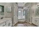 Bright bathroom with a walk-in glass shower, soaking tub, double sinks, and modern fixtures and cabinets at 210 Alta Vista St, Debary, FL 32713