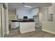 Modern open kitchen with an island, white cabinetry, and stainless steel microwave and lots of light at 210 Alta Vista St, Debary, FL 32713