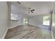 Open-concept living room featuring wood-look floors, ceiling fan and sliding glass doors to the outside at 210 Alta Vista St, Debary, FL 32713