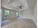 Spacious main bedroom featuring plush carpet, ceiling fan, and abundant natural light through multiple windows at 210 Alta Vista St, Debary, FL 32713