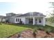 Well-maintained backyard with lush grass, covered patio, and pristine landscaping for outdoor living at 6069 Sacred Oak Ave, Mount Dora, FL 32757