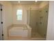 Spa-like bathroom featuring a soaking tub and a separate glass-enclosed shower with modern fixtures at 6069 Sacred Oak Ave, Mount Dora, FL 32757