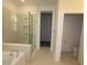 Elegant bathroom featuring a soaking tub, walk-in shower with glass door, and neutral color palette at 6069 Sacred Oak Ave, Mount Dora, FL 32757