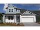 Charming two-story home with a blue accent and attached two-car garage at 6069 Sacred Oak Ave, Mount Dora, FL 32757