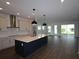 Open concept kitchen and living area with a large center island and lots of natural light at 6069 Sacred Oak Ave, Mount Dora, FL 32757