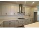 Modern kitchen featuring a stainless steel vent hood and sleek countertops at 6069 Sacred Oak Ave, Mount Dora, FL 32757