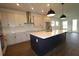 Modern kitchen featuring a large center island, stainless appliances, and tile backsplash at 6069 Sacred Oak Ave, Mount Dora, FL 32757