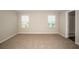Bright bedroom features carpet flooring, neutral walls, two windows and an ensuite bathroom at 1046 Foreshore Ln, Haines City, FL 33844