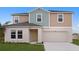 Inviting two-story home featuring a two-car garage, well-maintained lawn, and a charming light yellow front door at 1046 Foreshore Ln, Haines City, FL 33844