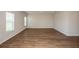 Spacious living room with wood-look flooring, neutral walls, and two large windows for natural light at 1046 Foreshore Ln, Haines City, FL 33844