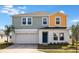 Two-story home featuring a two-car garage and a mix of blue and yellow siding at 1042 Foreshore Ln, Haines City, FL 33844