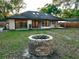 View of backyard including stone fire pit with view of rear of home at 1507 Wheeler Rd, Apopka, FL 32703