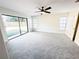 Large bedroom with new carpet, large glass sliding doors to the backyard, and a modern ceiling fan at 1507 Wheeler Rd, Apopka, FL 32703