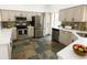 A modern kitchen features stainless steel appliances, counter tops and a tile floor at 1507 Wheeler Rd, Apopka, FL 32703