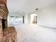 Spacious carpeted living room with brick fireplace and views of the backyard at 1507 Wheeler Rd, Apopka, FL 32703